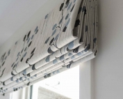 Designer fabric roman blinds 47 on a window.